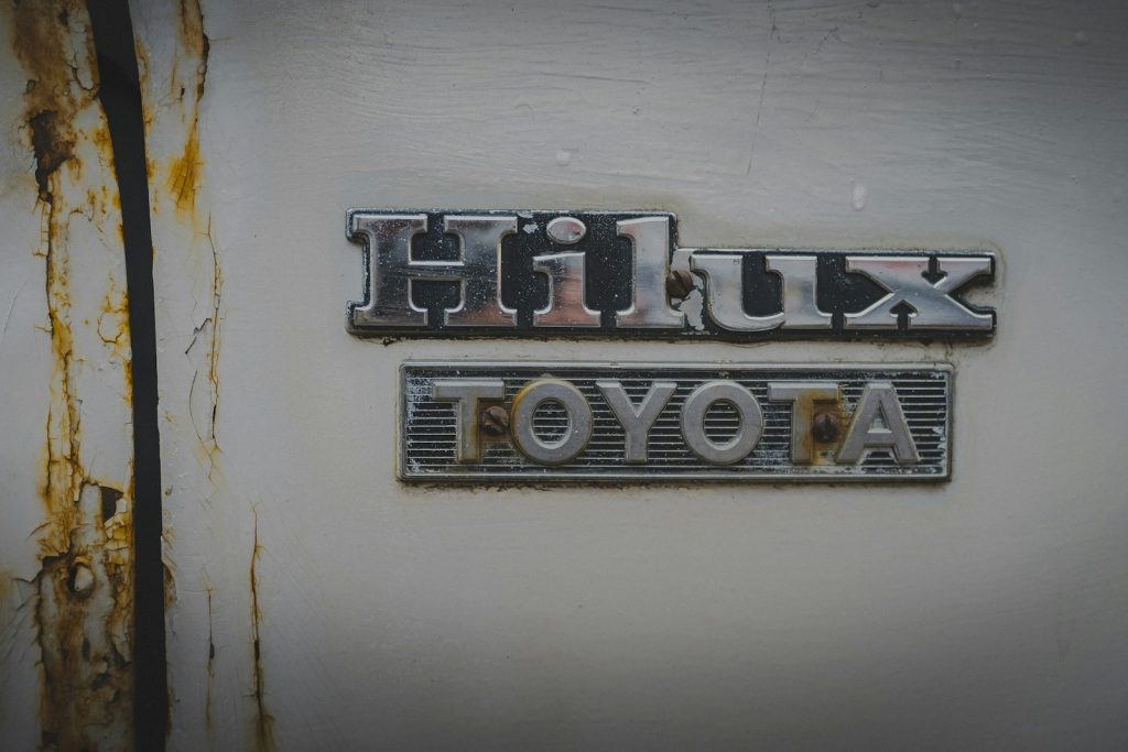 Rusted toyota hilux emblem on a white surface